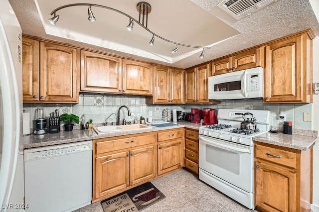 kitchen with decorative backsplash, a textured ceiling, white appliances, and sink