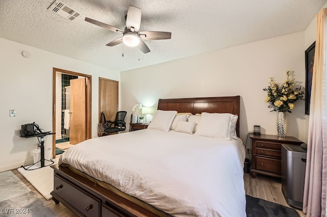 bedroom with ceiling fan, light hardwood / wood-style floors, and a textured ceiling