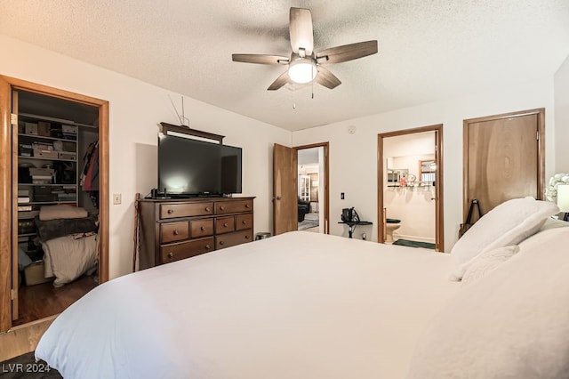 bedroom featuring connected bathroom, ceiling fan, wood-type flooring, a textured ceiling, and a closet