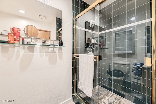 bathroom with toilet and a shower with shower door