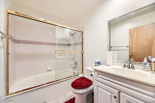 full bathroom featuring tile patterned flooring, toilet, combined bath / shower with glass door, and vanity