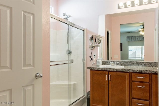 bathroom featuring ceiling fan, a shower with shower door, and vanity