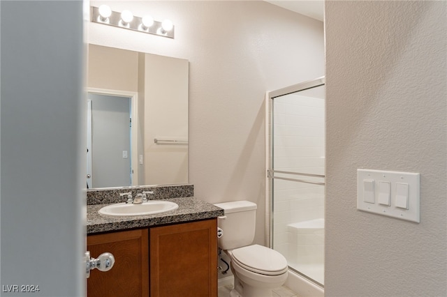 bathroom featuring vanity, toilet, and a shower with shower door