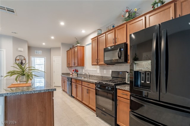 kitchen featuring tasteful backsplash, stone counters, sink, and black appliances