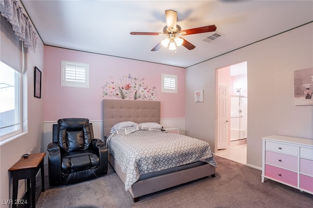 carpeted bedroom with ensuite bath and ceiling fan