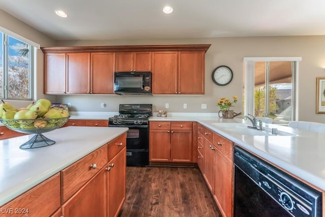 kitchen with dark hardwood / wood-style floors, a wealth of natural light, sink, and black appliances