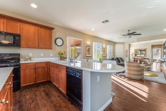 kitchen with dark hardwood / wood-style flooring, sink, black appliances, and ceiling fan