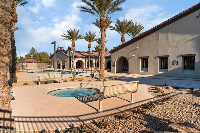 view of swimming pool with a hot tub and a patio area