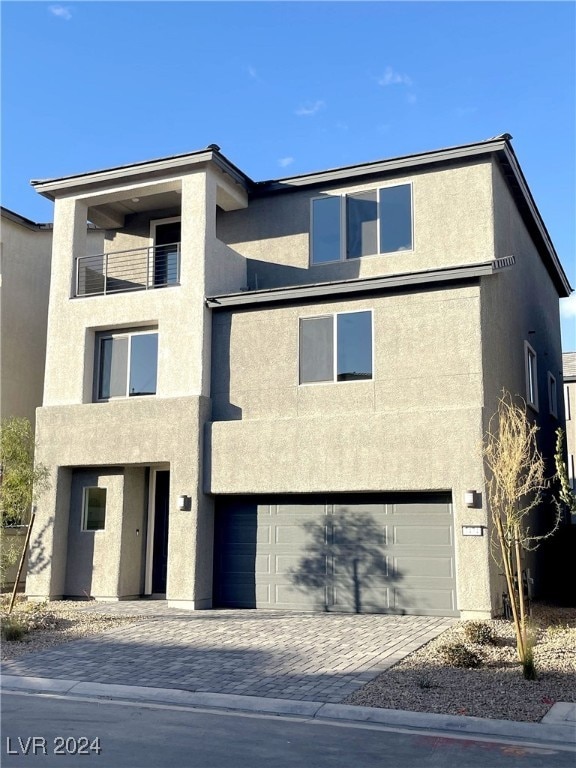 view of front of property with an attached garage, decorative driveway, and stucco siding