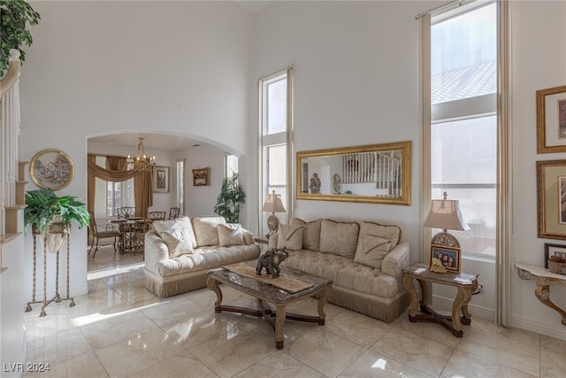 living room with a towering ceiling and a notable chandelier