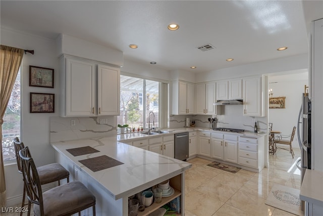 kitchen featuring white cabinetry, sink, kitchen peninsula, and backsplash