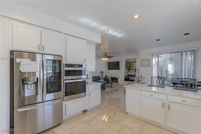 kitchen with white cabinets, ceiling fan, and stainless steel appliances