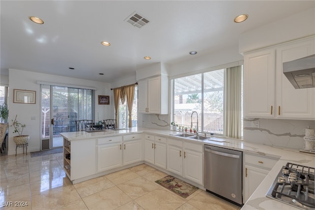 kitchen with white cabinets, sink, decorative backsplash, appliances with stainless steel finishes, and kitchen peninsula