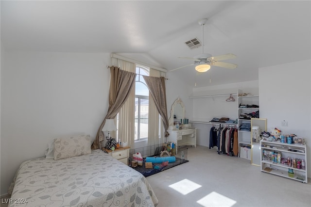 carpeted bedroom with ceiling fan, a closet, and lofted ceiling