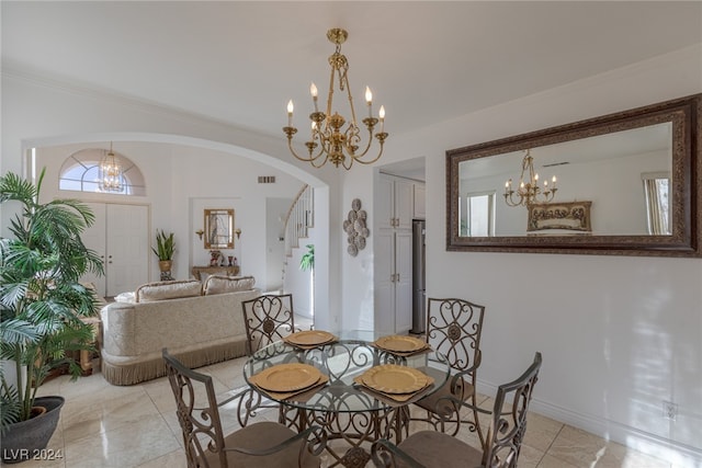 tiled dining room featuring crown molding and an inviting chandelier