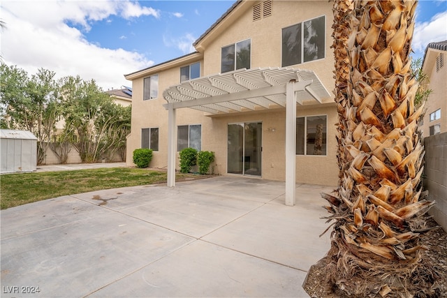 back of property with a pergola, a patio, and a storage shed