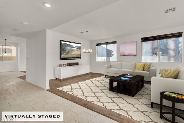 living room with hardwood / wood-style floors and a notable chandelier