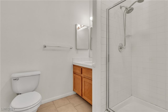 bathroom with tiled shower, tile patterned floors, vanity, and toilet