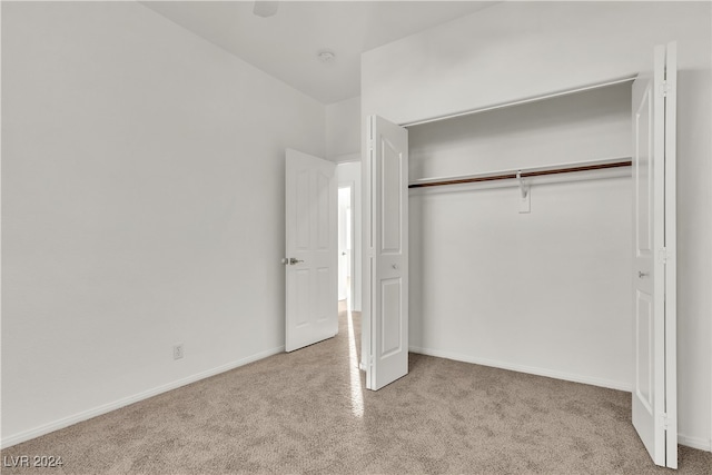 unfurnished bedroom with light carpet and a closet