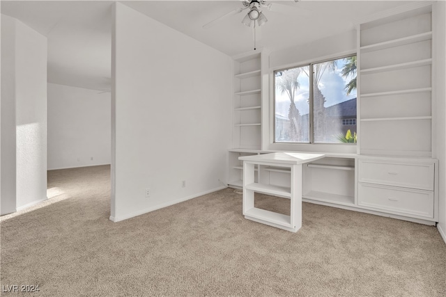 unfurnished office featuring ceiling fan and light carpet