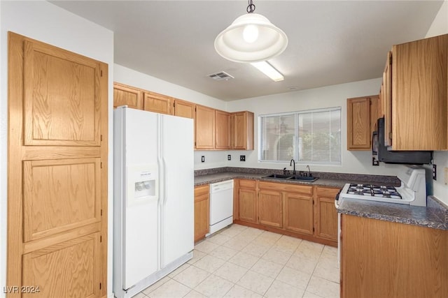 kitchen with white appliances, hanging light fixtures, and sink