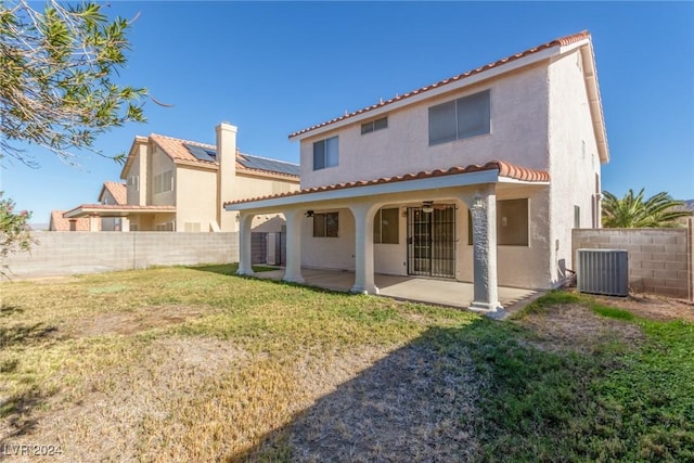 back of house with a patio area, a yard, and central AC