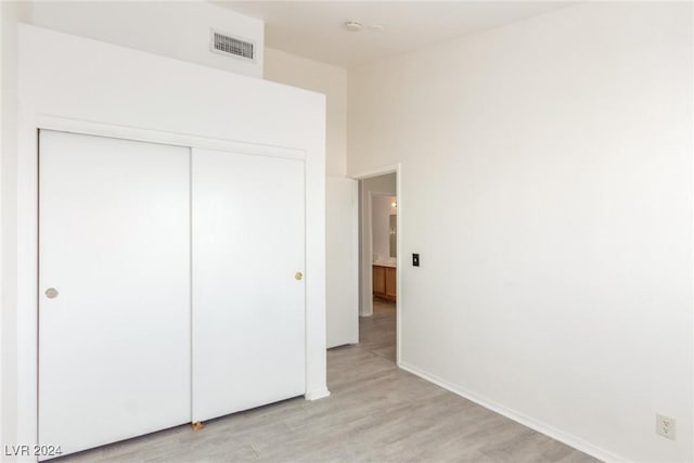 unfurnished bedroom featuring light wood-type flooring and a closet