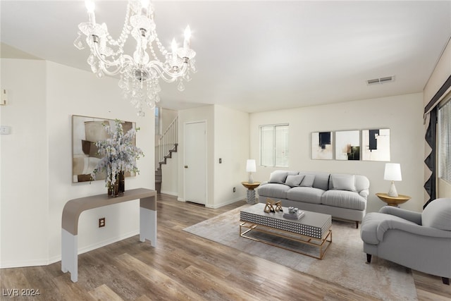 living room with wood-type flooring and a chandelier