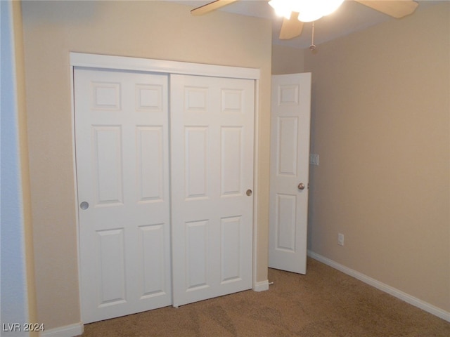 unfurnished bedroom featuring ceiling fan, a closet, and carpet