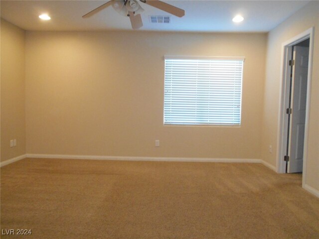 spare room with ceiling fan and carpet