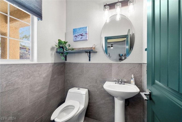 bathroom featuring tile walls, ceiling fan, and toilet