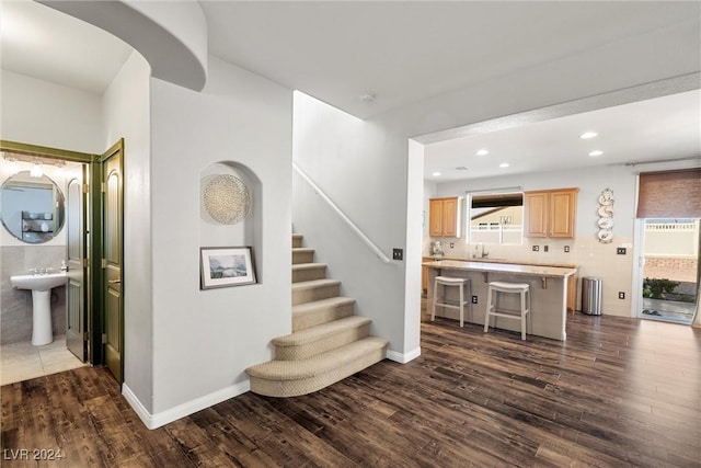 stairway with sink and wood-type flooring