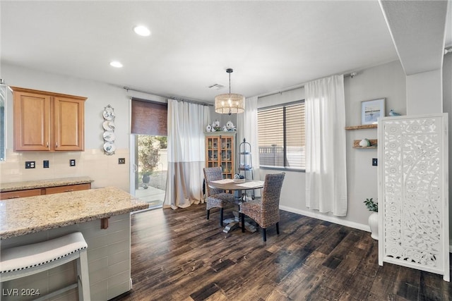 dining room with dark hardwood / wood-style flooring and an inviting chandelier