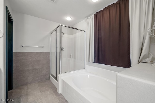 bathroom with tile walls and plus walk in shower