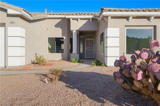 property entrance with a tiled roof and stucco siding