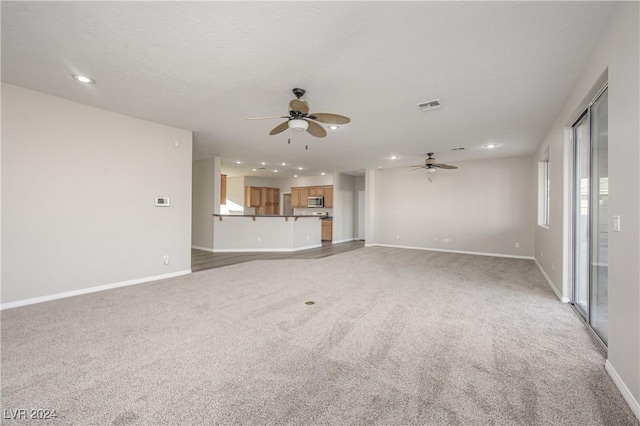 unfurnished living room featuring visible vents, recessed lighting, baseboards, light colored carpet, and ceiling fan