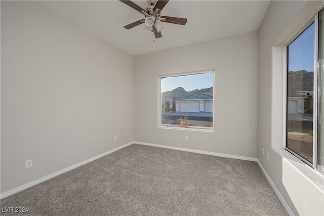 carpeted spare room with ceiling fan