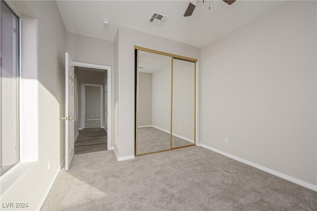 unfurnished bedroom featuring baseboards, visible vents, ceiling fan, a closet, and carpet flooring