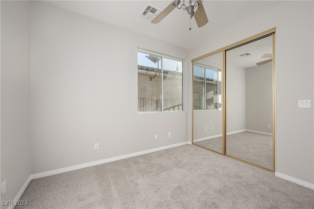 unfurnished bedroom with a ceiling fan, carpet, visible vents, baseboards, and a closet