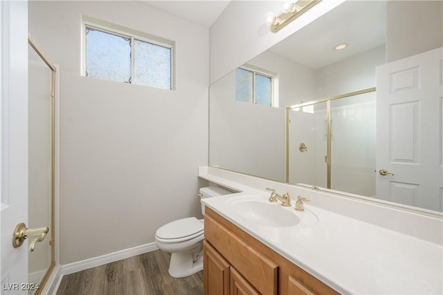 full bath featuring a shower stall, baseboards, toilet, wood finished floors, and vanity