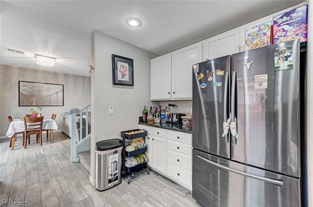 kitchen featuring white cabinetry, stainless steel refrigerator, and light hardwood / wood-style flooring