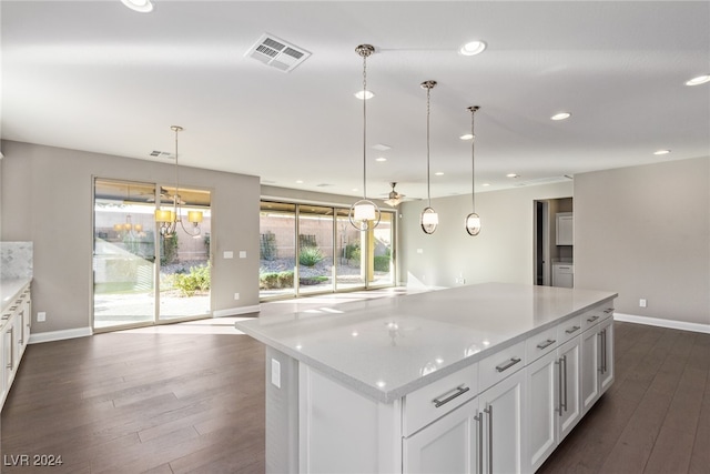 kitchen featuring white cabinets, dark hardwood / wood-style floors, decorative light fixtures, and a kitchen island