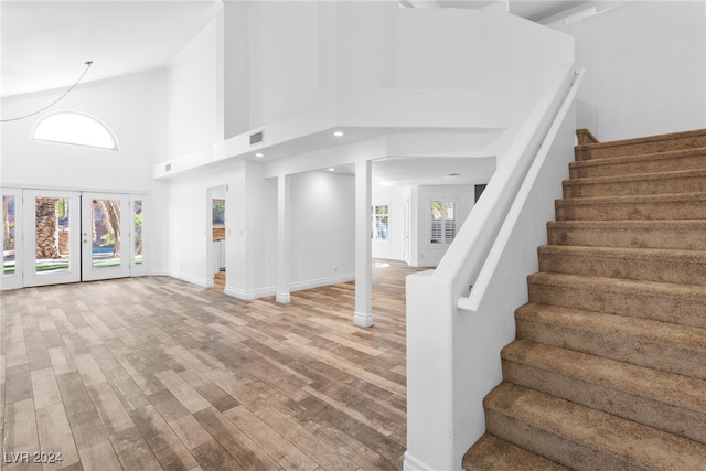 interior space featuring hardwood / wood-style floors, high vaulted ceiling, and french doors