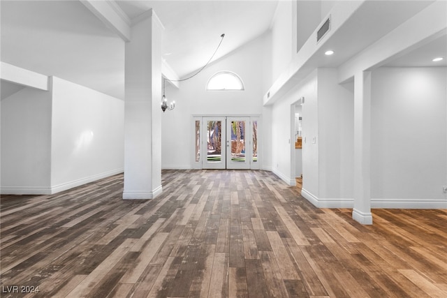 unfurnished living room with french doors, high vaulted ceiling, and dark hardwood / wood-style floors