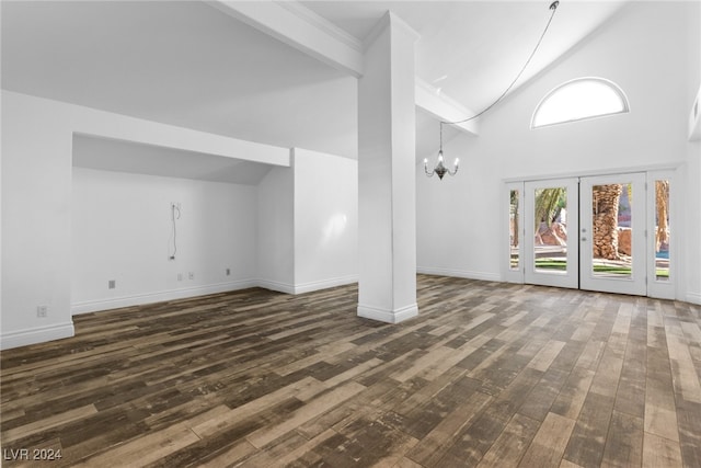 unfurnished living room with a notable chandelier, beam ceiling, dark hardwood / wood-style flooring, and high vaulted ceiling