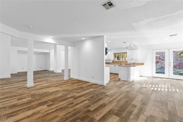 basement with sink, french doors, and light wood-type flooring