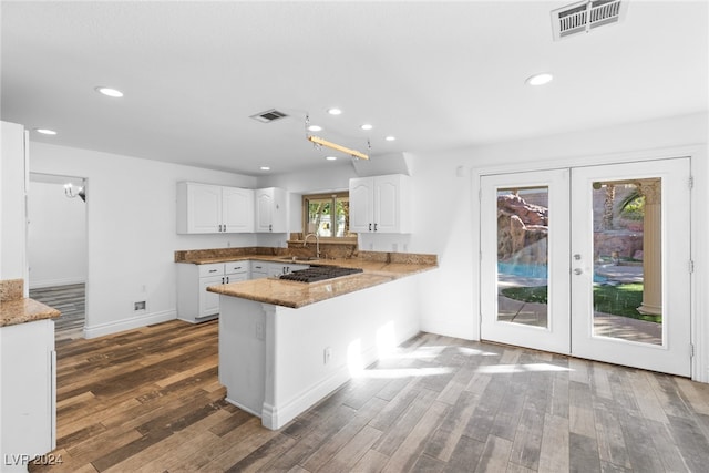 kitchen featuring kitchen peninsula, white cabinetry, french doors, and dark hardwood / wood-style floors