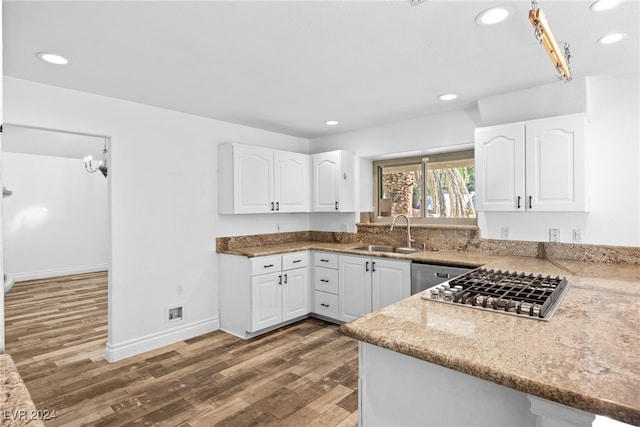 kitchen featuring white cabinets, dark hardwood / wood-style flooring, light stone counters, and sink