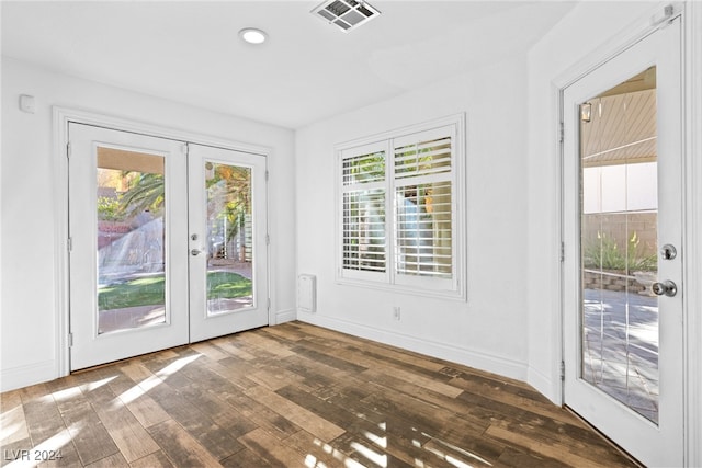 entryway with dark hardwood / wood-style flooring, plenty of natural light, and french doors