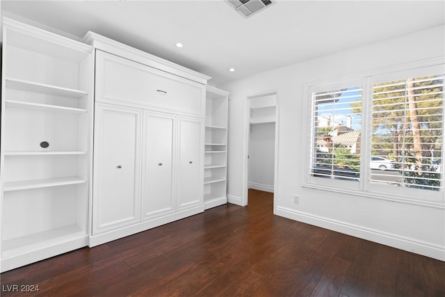 unfurnished bedroom with dark hardwood / wood-style flooring